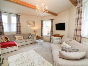 a living room with a couch and a chandelier at Lonsdale Cottage in Carnforth