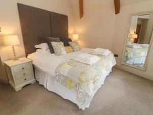 a bedroom with a large bed and a mirror at Lonsdale Cottage in Carnforth