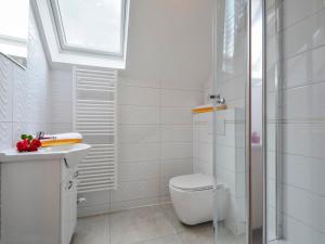 a white bathroom with a toilet and a sink at Ubytovanie pod Tatrami in Nová Lesná