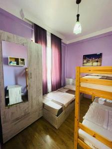 Pokój z 2 łóżkami piętrowymi i fioletowymi ścianami w obiekcie House Magda w mieście Batumi