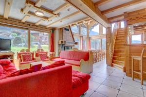 a living room with red couches and a tv at Aconits in Morzine