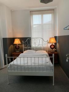 sypialnia z białym łóżkiem z 2 lampami w obiekcie Cracow bb w Krakowie