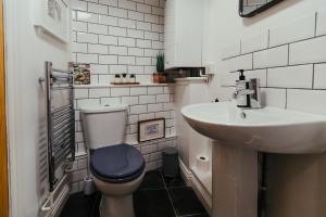 a bathroom with a toilet and a sink at By the Way in Great Malvern