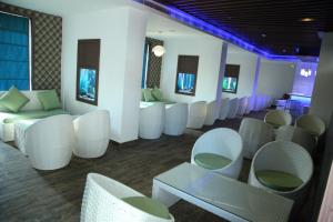 a waiting room with white chairs and tables at Paravoor Galaxy Hotel in Cherai Beach