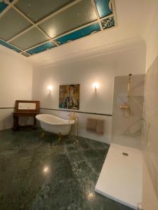 baño con bañera y una pintura en la pared en Dimora Castelli en Chieti