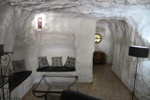 a room in a cave with a table and pillows at CUEVAS AL ANDALUS - Alegria in Orce