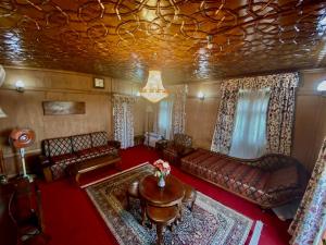 a living room with couches and a chandelier at Green Paradise Houseboat - Centrally Heated in Srinagar