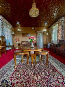 een woonkamer met een tafel en een bank bij Green Paradise Houseboat - Centrally Heated in Srinagar