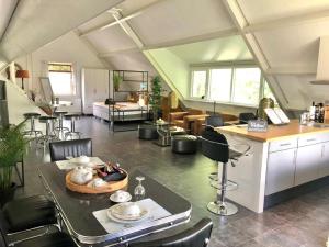 eine Küche und ein Wohnzimmer mit Tisch und Stühlen in der Unterkunft De Weideblom in Schermerhorn