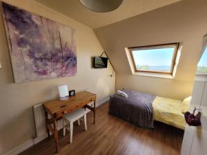 a bedroom with a desk and a bed and a window at Dolphin House in Preesall