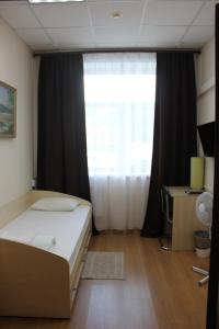 a bedroom with a bed and a large window at Гостиница Бизнес Турист in Barnaul
