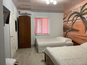 プリモースコアイにあるBaza Otdyha Primor'eのベッド2台とヤシの木の壁画が備わる客室です。