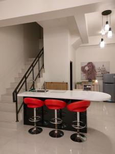 una cocina con encimera blanca y taburetes rojos en Touch 星空包棟民宿寵物友善民宿 en Wujie