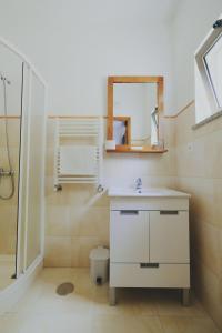 y baño con lavabo, espejo y ducha. en Casa do Lago - Geres, en Gerês