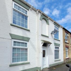 a white building with windows and a white door at The little seaside cottage in Bridlington
