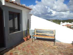 een bank op een patio naast een gebouw bij Casa do João in Barão de São João