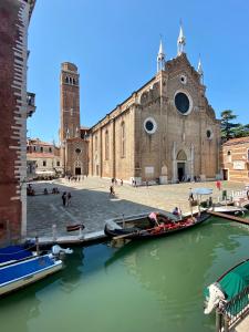 eine Kirche mit Booten im Wasser davor in der Unterkunft Suite Veronica & Maison Laguna in Venedig