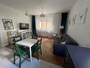 uma sala de estar com um sofá, uma mesa e cadeiras em Woodland Apartment em Gdynia