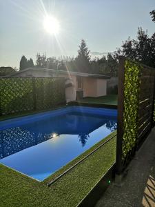 a blue swimming pool in a yard with a fence at Penzion Ivana in Valašské Meziříčí