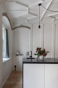 una cucina con pareti bianche e un soffitto con un bancone nero di Ida - historic town apartments a Vipiteno