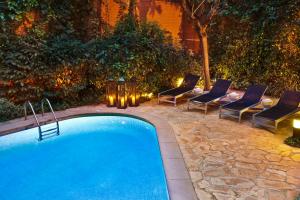 een zwembad met stoelen en een tafel met verlichting bij Hotel Balmes, a member of Preferred Hotels & Resorts in Barcelona