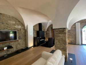 a living room with a couch and a tv on a stone wall at Casa Rural el Serrat de Baix in Sant Joan les Fonts