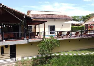ein Haus mit einem Balkon mit Stühlen darauf in der Unterkunft Fincas Panaca H10 - Luxury Villa with Pool & Jacuzzi in Quimbaya