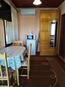 a dining room with a table and a refrigerator at Къща Рачеви in Tryavna