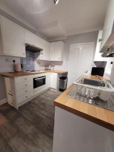 a kitchen with white cabinets and a counter top at The little seaside cottage in Bridlington