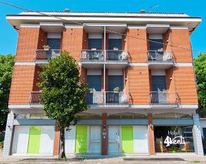 a red brick building with a tree in front of it at 4 Venti in Curtatone