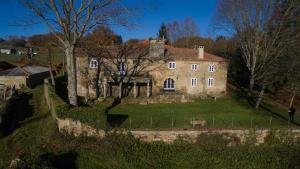 una vecchia casa in pietra su una collina erbosa di Pazo del siglo XVII en el corazón de Galicia a Lalín