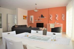 Una sala de estar con una mesa y sillas blancas. en Rezidenca Primavera Apartments, en Durrës