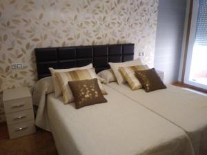 ein Schlafzimmer mit zwei Betten mit Kissen in der Unterkunft Apartamento Las Carolinas in Ribeira