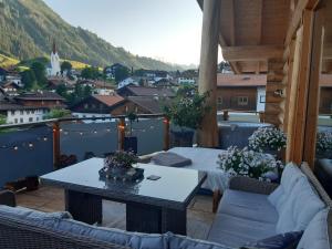 a balcony with a table and a view of a city at Hideaway Zugspitz Berwang in Berwang