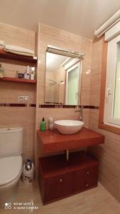 ein Badezimmer mit Waschbecken, Toilette und Spiegel in der Unterkunft Apartamento Las Carolinas in Ribeira + 7 Fotos