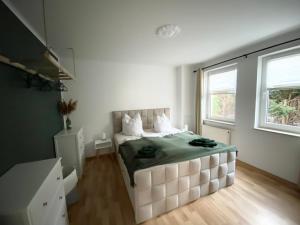una camera da letto con un grande letto bianco con una coperta verde di Spreewald-Apartment I Netflix I Prime I Parkplatz a Burg