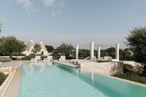 una piscina con sedie e un resort di Trullo Piccolo ad Alberobello