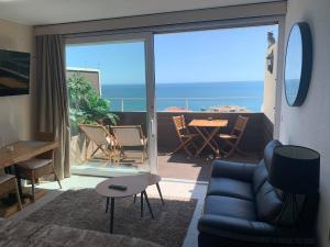 - un salon avec un canapé et une vue sur l'océan dans l'établissement SOLARIS PANORAMIC studio vue mer, à Portimão