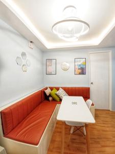 ein Wohnzimmer mit einem roten Sofa und einem weißen Tisch in der Unterkunft Seawind Cozy 2Br Modern Scandinivian in Davao City