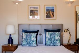 ein Schlafzimmer mit einem Bett mit blauen und weißen Kissen in der Unterkunft Blue Bamboo Hotel - Duna Parque Resorts & Hotels in Vila Nova de Milfontes
