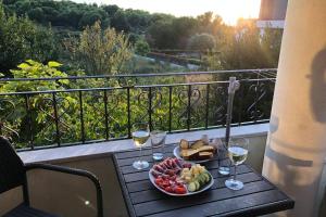 a table with a plate of food and glasses of wine at Beautiful apartment at entrance to Cape Kamenjak in Premantura