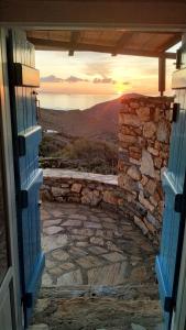 eine offene Tür mit Blick auf den Sonnenuntergang in der Unterkunft Spiti Anita, Superior Master & Double Room - Pristine, Serene, Beautiful Views in Gavrio
