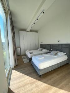 a bedroom with two beds and a large window at Getaway Room Palase in Palasë