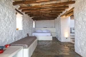 1 dormitorio con 2 camas y pared de piedra en Spiti Anita, Superior Master & Double Room - Pristine, Serene, Beautiful Views, en Gavrion