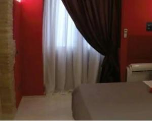 a bedroom with a bed and a window with curtains at Al Castello in Cagliari