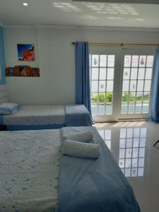 a bedroom with two beds and a large window at Holiday Loft Suite Apartamento in San Andrés