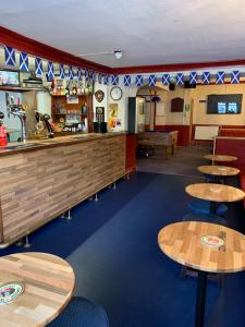 a restaurant with wooden tables and a bar at Grant Arms Hotel in Cullen