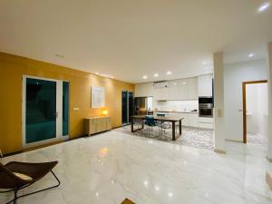 a large living room with a table and a kitchen at Villas Calhau da Lapa 51 in Campanário