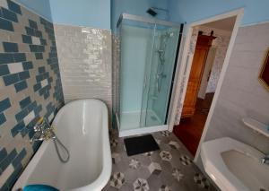 un bagno con vasca, doccia e lavandino di Chateau Gunes (Guges) a Cissac-Médoc Altre 20 foto