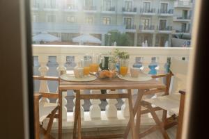 einen Tisch mit Gläsern Orangensaft auf dem Balkon in der Unterkunft Casa Di Mare II in Olympiakí Aktí